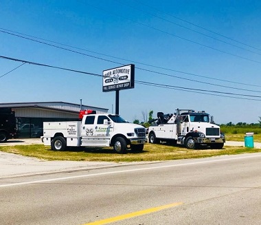 tow trucks in front of shop sign